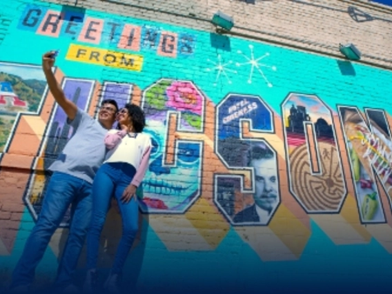 Students taking a picture in front of Tucson Mural