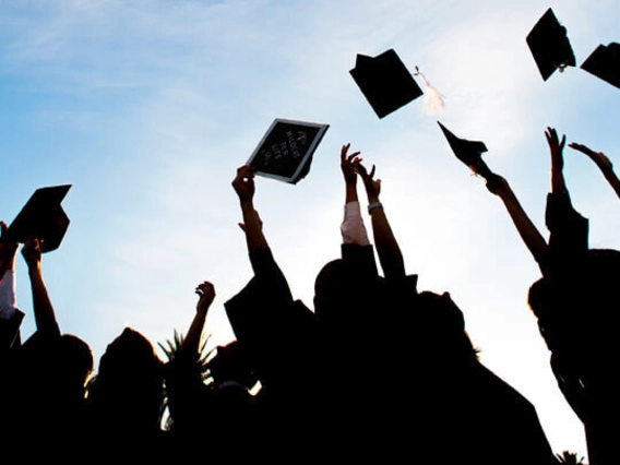 Graduating students throwing their caps in the air