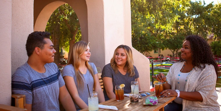 Students enjoying coffee at main gate square outside patio